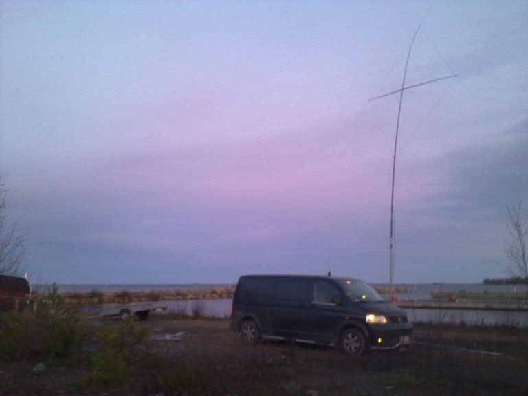 A Volkswagen van by the sea with an antenna behind it